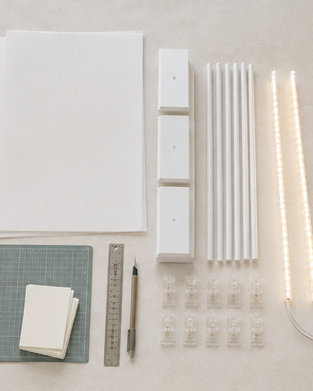 Vellum sheets, white sail-frame components, warm LED strips, clear clips and precision cutting tools